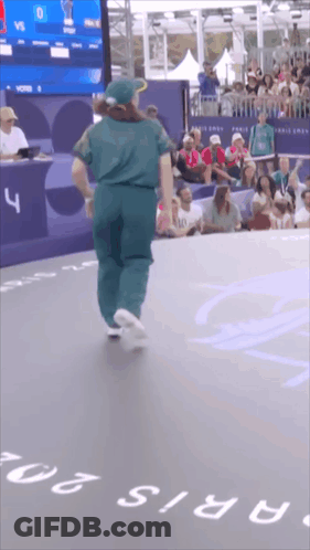 A Person Is Dancing In Front Of A Crowd And A Sign That Says Paris 20 GIF