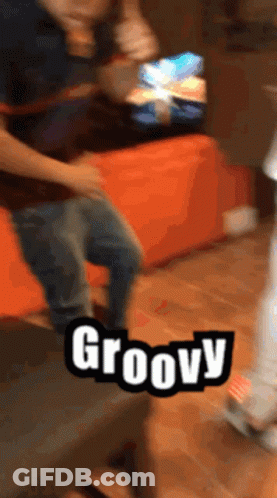 A Person Is Dancing In Front Of A Sign That Says Groovy On It GIF