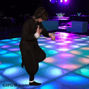 A Person Is Dancing On A Dance Floor With Blue And Purple Lights Behind Them GIF