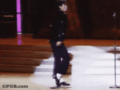 A Person Is Dancing On A Stage In Front Of A Microphone GIF
