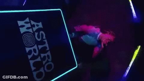 A Person Is Dancing On A Stage In Front Of A Sign That Says Astro World . GIF