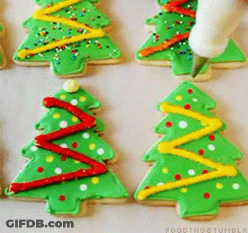 A Person Is Decorating Christmas Trees With Green Frosting GIF