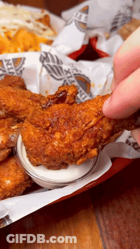 A Person Is Dipping A Piece Of Fried Chicken In Ranch Sauce GIF