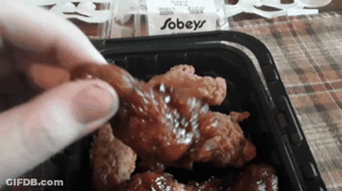 A Person Is Dipping A Piece Of Fried Chicken Into A Sauce That Says Sobeys On It GIF
