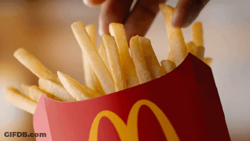A Person Is Dipping French Fries Into A Red Mcdonald 'S Container GIF