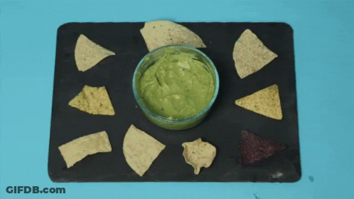 A Person Is Dipping Tortilla Chips Into Guacamole GIF