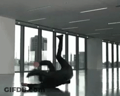 A Person Is Doing A Handstand In A Room With A Lot Of Windows GIF