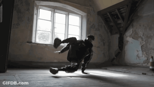 A Person Is Doing A Trick In A Dark Room With A Window GIF