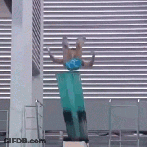 A Person Is Doing A Trick On A Diving Board In A Pool . GIF