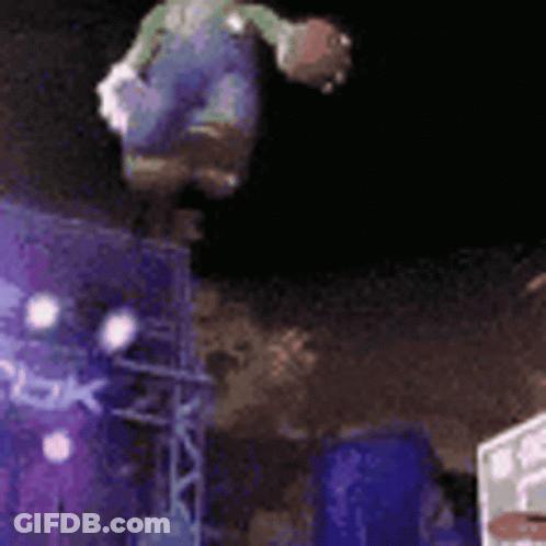 A Person Is Doing A Trick On A Trampoline In The Air At Night . GIF