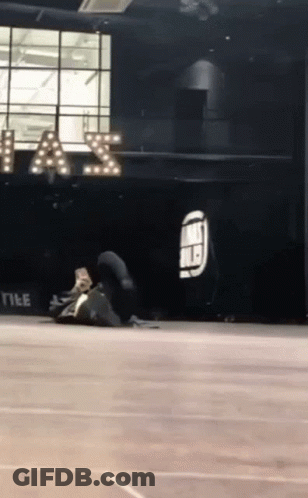 A Person Is Doing A Trick On The Floor In Front Of A Sign That Says " A & S " GIF