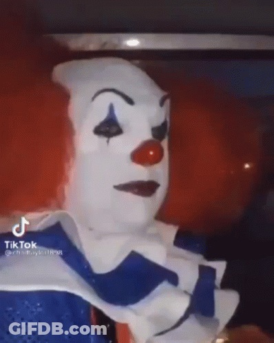 A Person Is Dressed As A Clown With A Red Nose And Blue Eyes . GIF