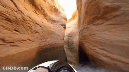 A Person Is Driving A Jet Ski Through A Canyon . GIF