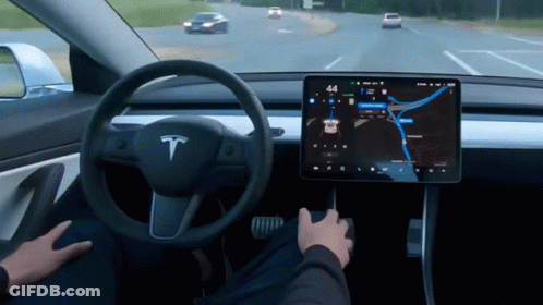 A Person Is Driving A Tesla Model 3 With The Time Of 4:44 GIF