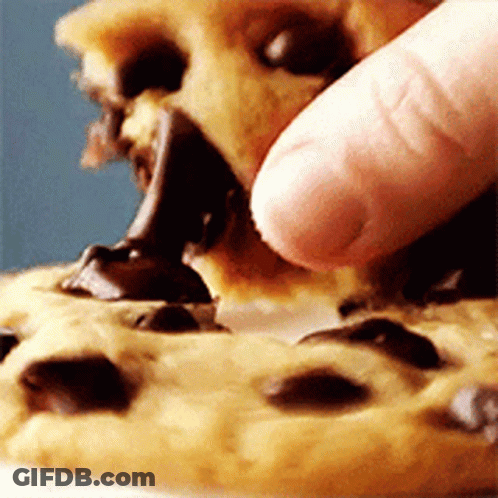 A Person Is Eating A Chocolate Chip Cookie With Their Fingers GIF