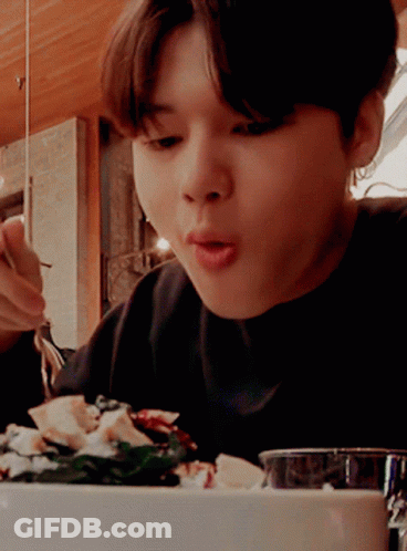 A Person Is Eating A Salad With A Fork And Spoon GIF