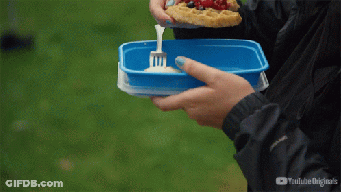 A Person Is Eating A Slice Of Pizza From A Blue Container With A Fork In It GIF