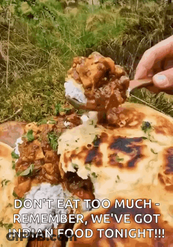 A Person Is Eating A Spoonful Of Food From A Plate Of Food . GIF