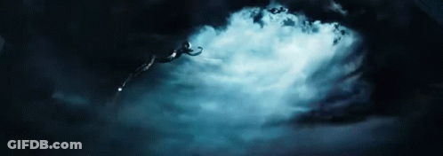 A Person Is Flying Through The Air In A Dark Cloudy Sky . GIF