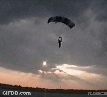 A Person Is Flying Through The Air With A Parachute And The Website Gifbin.com Is Visible In The Corner GIF