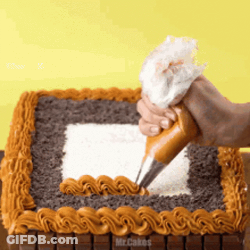 A Person Is Frosting A Cake That Says Mr Cakes On It GIF