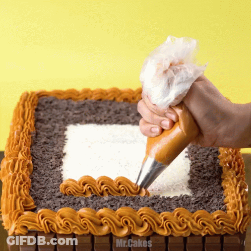 A Person Is Frosting A Cake With Mr.cakes Written In The Corner GIF