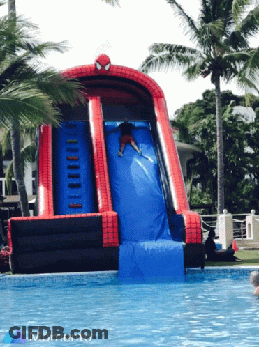A Person Is Going Down An Inflatable Spider Man Slide GIF