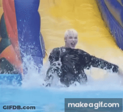 A Person Is Going Down An Inflatable Water Slide With Make A Gif.com In The Corner GIF