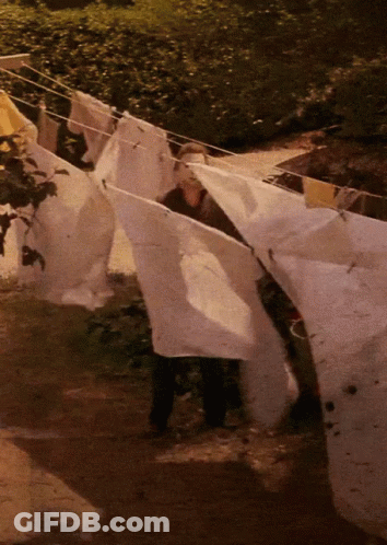 A Person Is Hanging Clothes On A Clothes Line At Night GIF
