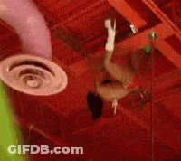 A Person Is Hanging From The Ceiling Of A Building GIF