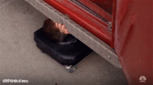 A Person Is Hiding Underneath A Fire Truck . GIF