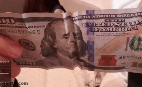A Person Is Holding A 100 Dollar Bill With The Number Mb4948 On It GIF