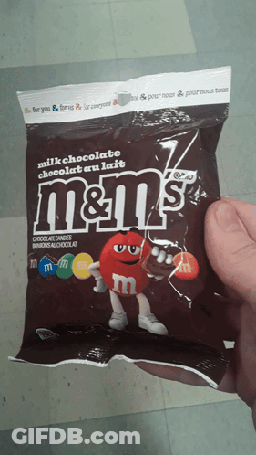 A Person Is Holding A Bag Of M & M 'S Milk Chocolate GIF