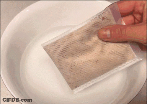 A Person Is Holding A Bag Over A Bowl Of Liquid GIF