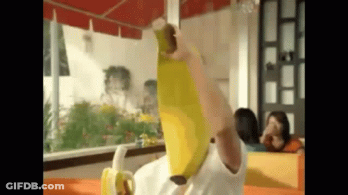 A Person Is Holding A Banana Over Their Head While Sitting At A Table . GIF