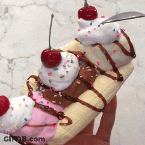 A Person Is Holding A Banana Split With Whipped Cream And Sprinkles GIF