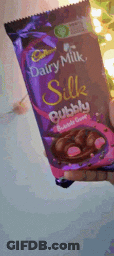 A Person Is Holding A Bar Of Cadbury Dairy Milk Silk Bubble Gum Chocolate GIF
