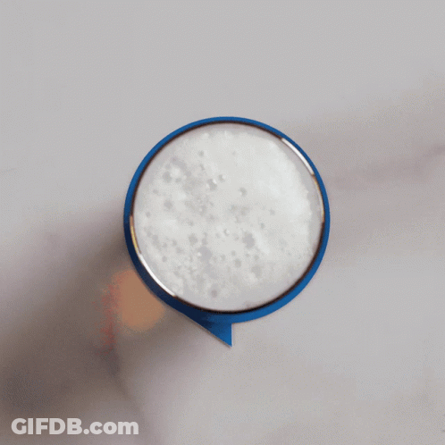 A Person Is Holding A Blue Speech Bubble With Foam On Top GIF