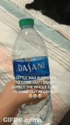 A Person Is Holding A Bottle Of Dasani Water In Their Hand GIF