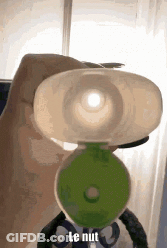 A Person Is Holding A Bottle With The Word Le Nut Written On It GIF