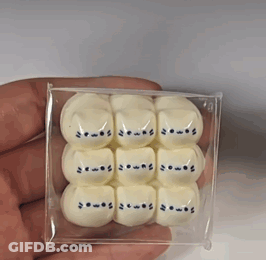 A Person Is Holding A Box Of White Marshmallows With Cats On Them GIF