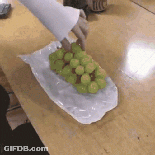 A Person Is Holding A Bunch Of Grapes In A Plastic Bag GIF
