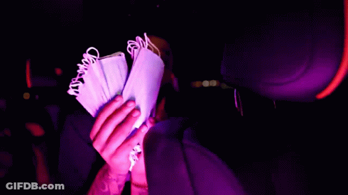 A Person Is Holding A Bunch Of Money In Their Hand GIF