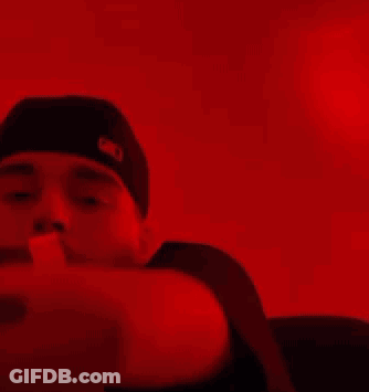 A Person Is Holding A Bunch Of Money In Their Hands In A Red Light . GIF