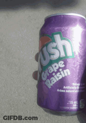 A Person Is Holding A Can Of Grape Raisin Crush GIF