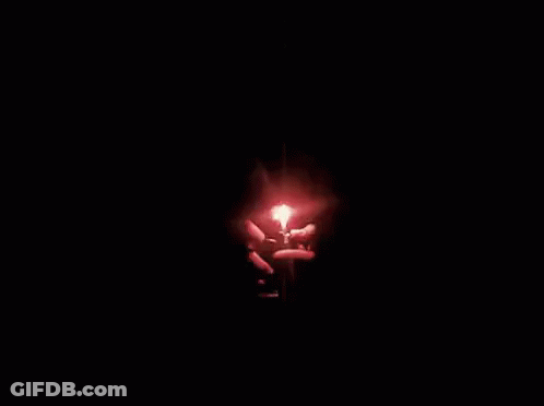 A Person Is Holding A Candle In The Shape Of A Heart With The Words `` Happy Anniversary '' Written Below It . GIF