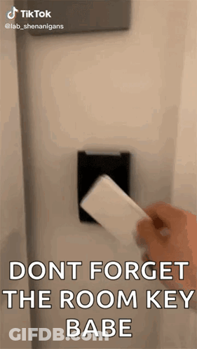 A Person Is Holding A Card In Front Of A Door . GIF