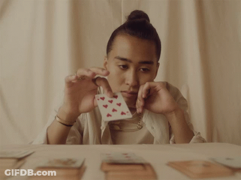 A Person Is Holding A Card With Hearts On It GIF