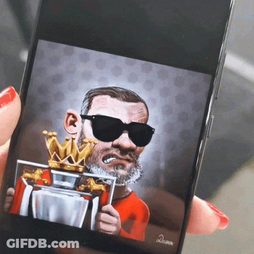 A Person Is Holding A Cell Phone With A Caricature Of A Man Wearing Sunglasses And A Crown GIF