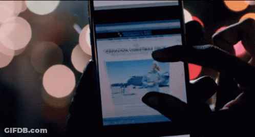 A Person Is Holding A Cell Phone With A Christmas Article On It GIF